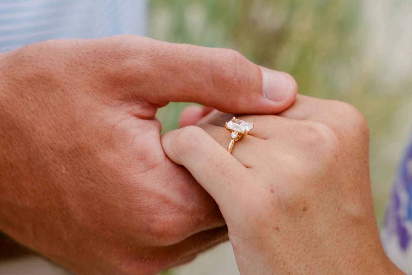 Close-up of hands and an engagement ring